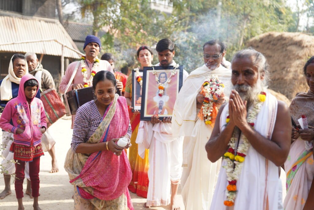 Devotees carry portraits in garlanded procession led by saint, Universal Peace Centre Lachhipur West Bengal Sunyoga event 2026