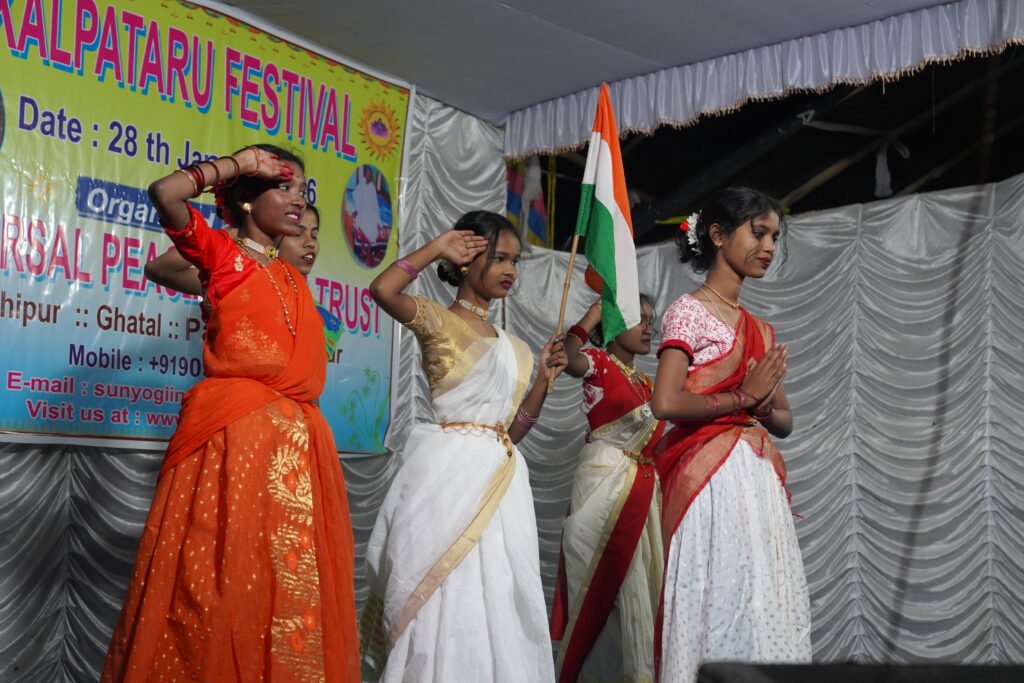 Kalpataru Festival stage: Ladies in orange, white saris honor national flag, Lachipur retreat